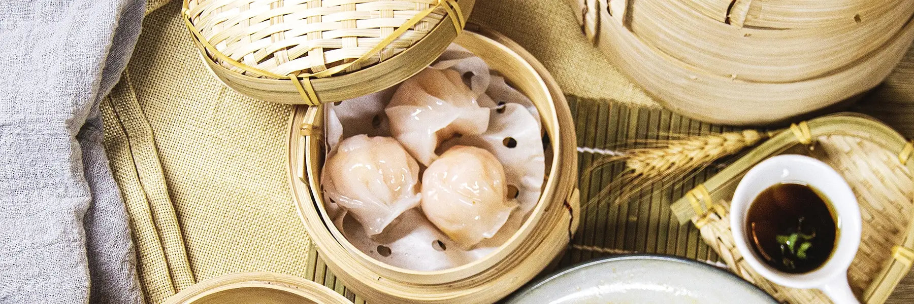 Dim Sum in bamboo steamer with dipping sauce