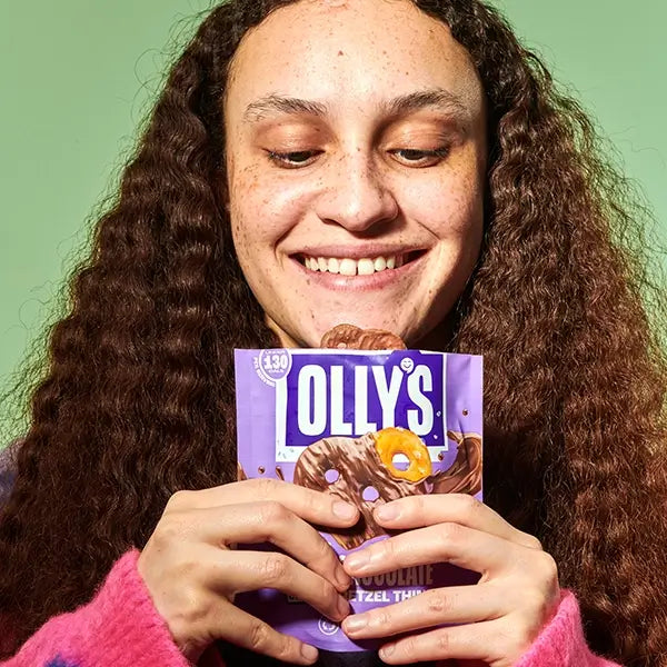 Olly's milk chocolate pretzel pouch being held by smiling person