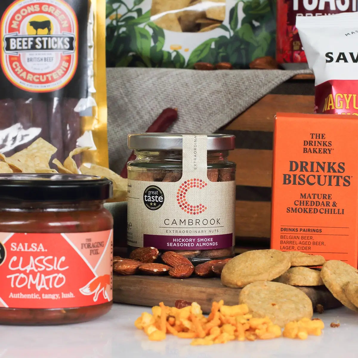 Assorted food products including jars, a box of biscuits, and a bag of beef sticks on a table.