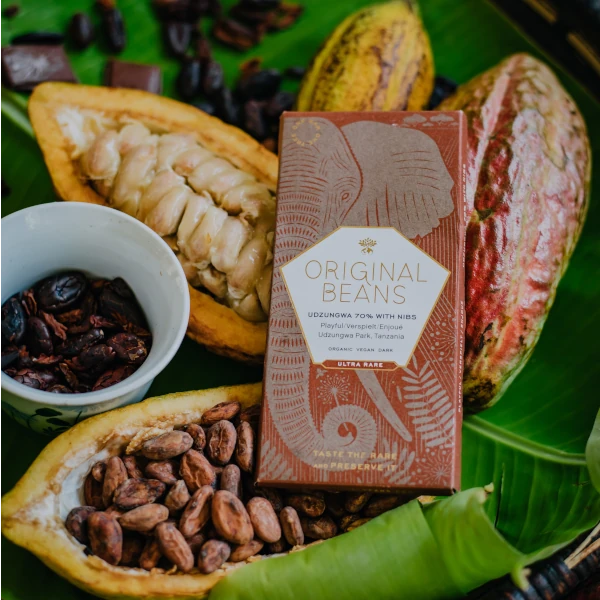  Original Beans - Udzungwa Chocolate Bar 70% 70g ontop of some open and closed cacao pods