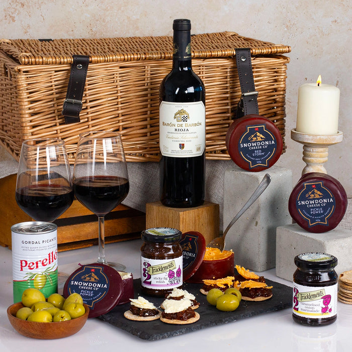 cheese and red wine in wicker basket