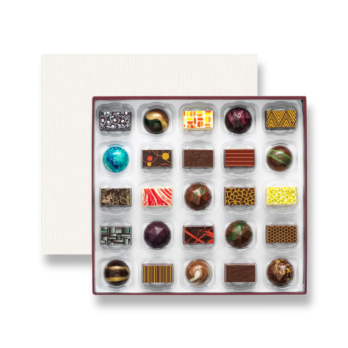 An open chocolate selection box containing 25 chocolates made by Harry Specters. The chocolates seen within this gift box are a colourful mix of white, milk, and dark chocolate.