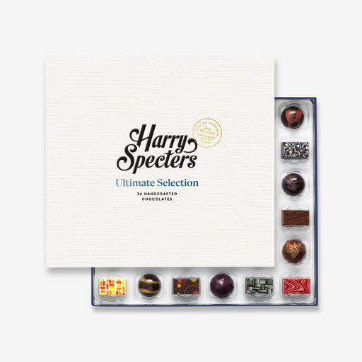 A chocolate selection box containing 36 chocolates, partially covered by a lid showing the name Harry Specters. The chocolates seen within this gift box are a colourful mix of white, milk, and dark chocolate.