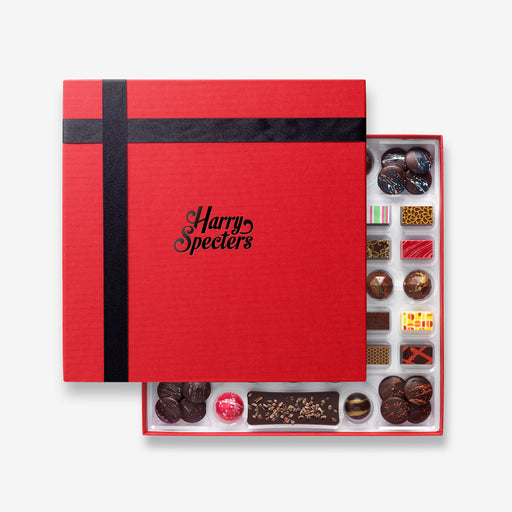 A chocolate selection box containing 55 chocolates, partially covered by a lid showing the name Harry Specters. The chocolates seen within this gift box are a colourful mix of white, milk, ruby, caramel, and dark chocolate, with coffee beans, mini chocolate bars, and hot chocolate buttons with two Thank You themed chocolates.